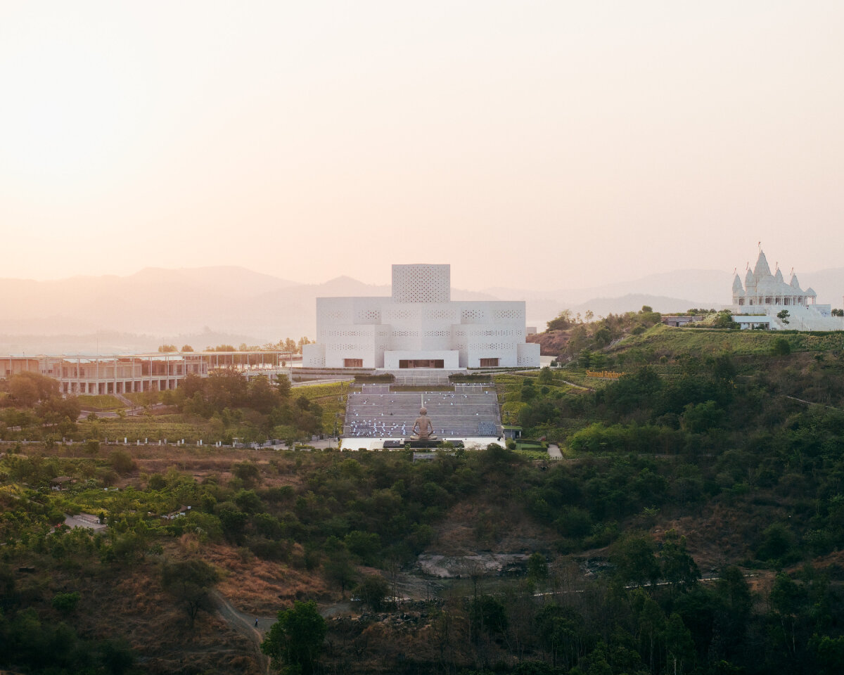 sequence of curved white marble volumes shape serie architects' ashram auditorium in india