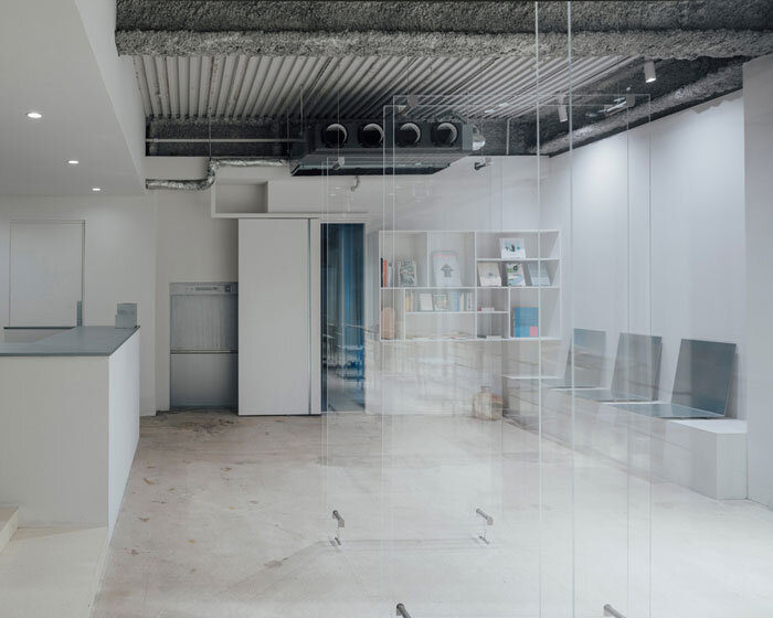 1975 men's hair salon by fathom unfolds within transparent acrylic frame in hiroshima