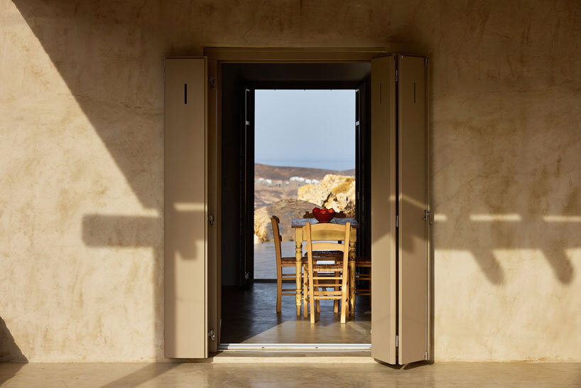 exposed stone masonry fuses restored residence by c-o lab with greek island's rocky terrain