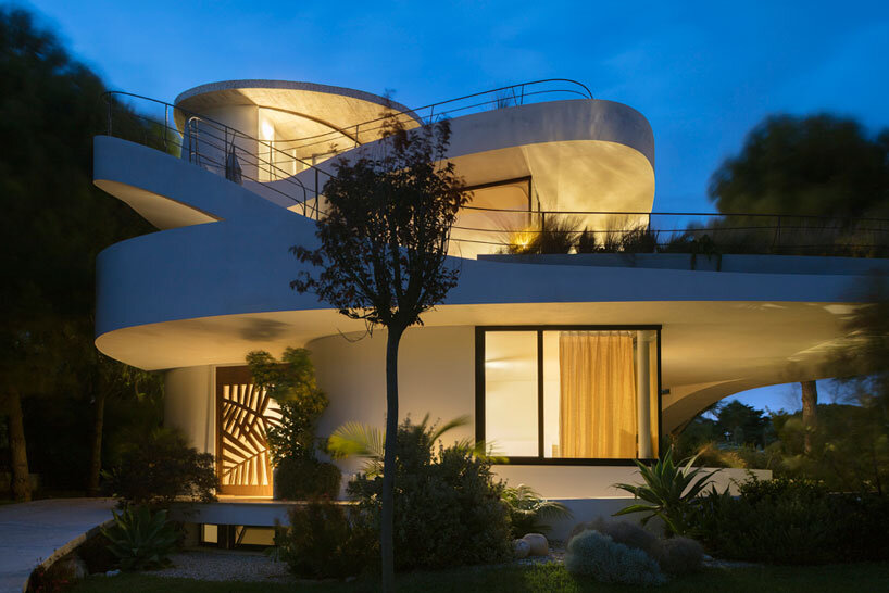 curved white volumes and verdant surroundings define house in les rotes, spain
