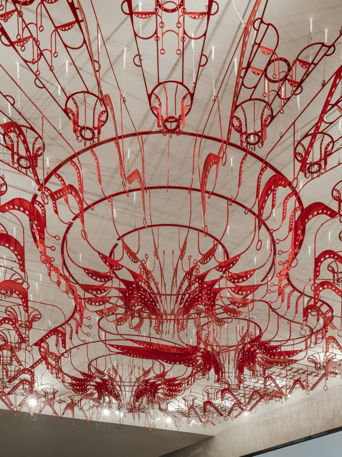 poh sin studio's intricate, mechanical red chandelier suspends from malaysia office ceiling