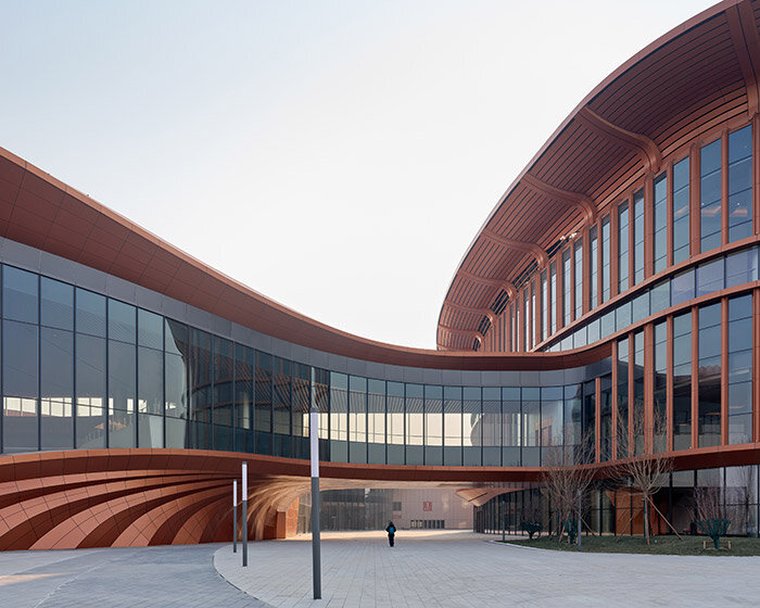 zaha hadid's beijing convention center shaped as series of copper-colored 'ribbons'