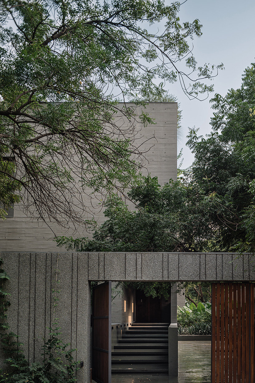 square openings punctuate wood-textured concrete facade of studio saransh's house in india