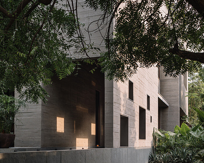 square openings punctuate wood-textured concrete facade of studio saransh's house in india