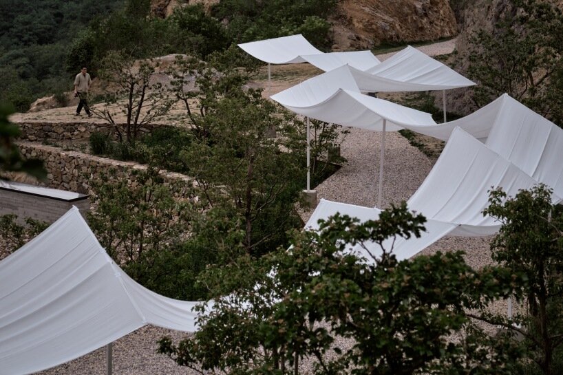 team_bldg's white gauze installation flutters and chimes soft bells in ancient valley in china