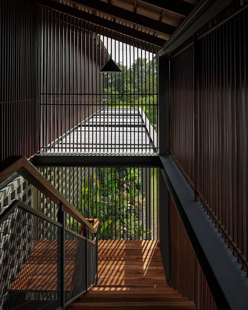facade of repurposed wood fronts multi-generational house in uthai thani, thailand