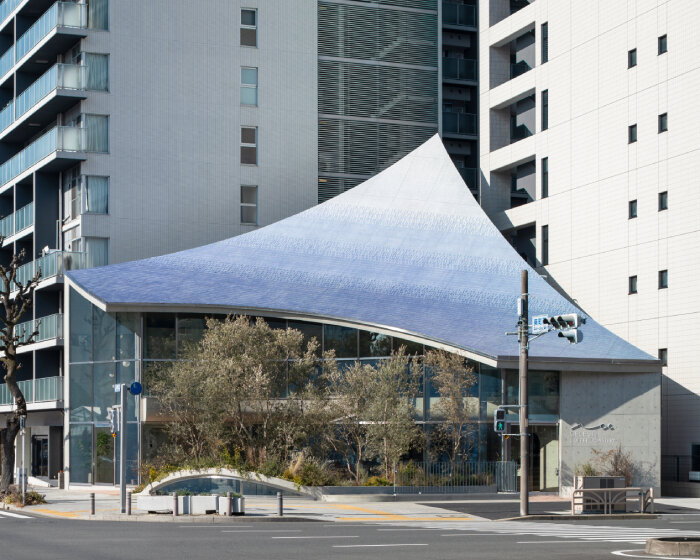 canopy of 28,000 glistening tiles sweeps over yuko nagayama's café in japan