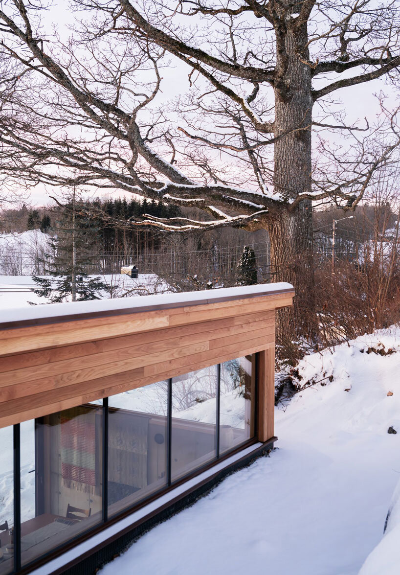 clad in oak panels, folly by rever & drage extends angular cantilever form over norwegian hill
