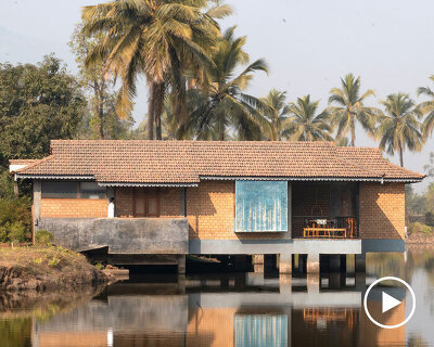 pond houses crafted from earth blocks float above land and water in india