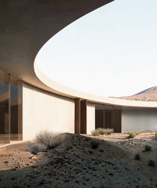 pragma carves rock art visitor's center into rugged terrain of archaeological site in UAE