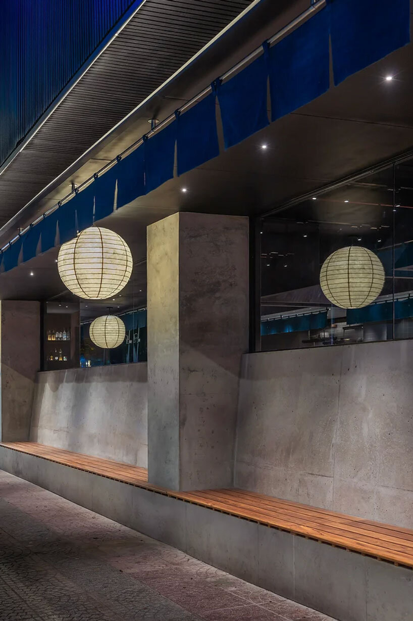 indigo fabric partitions float above sculpted concrete counters in rokusho bar by inrestudio