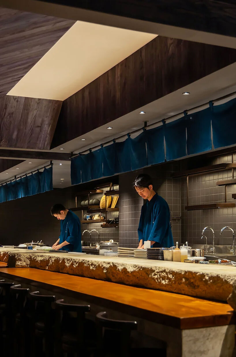 indigo fabric partitions float above sculpted concrete counters in rokusho bar by inrestudio
