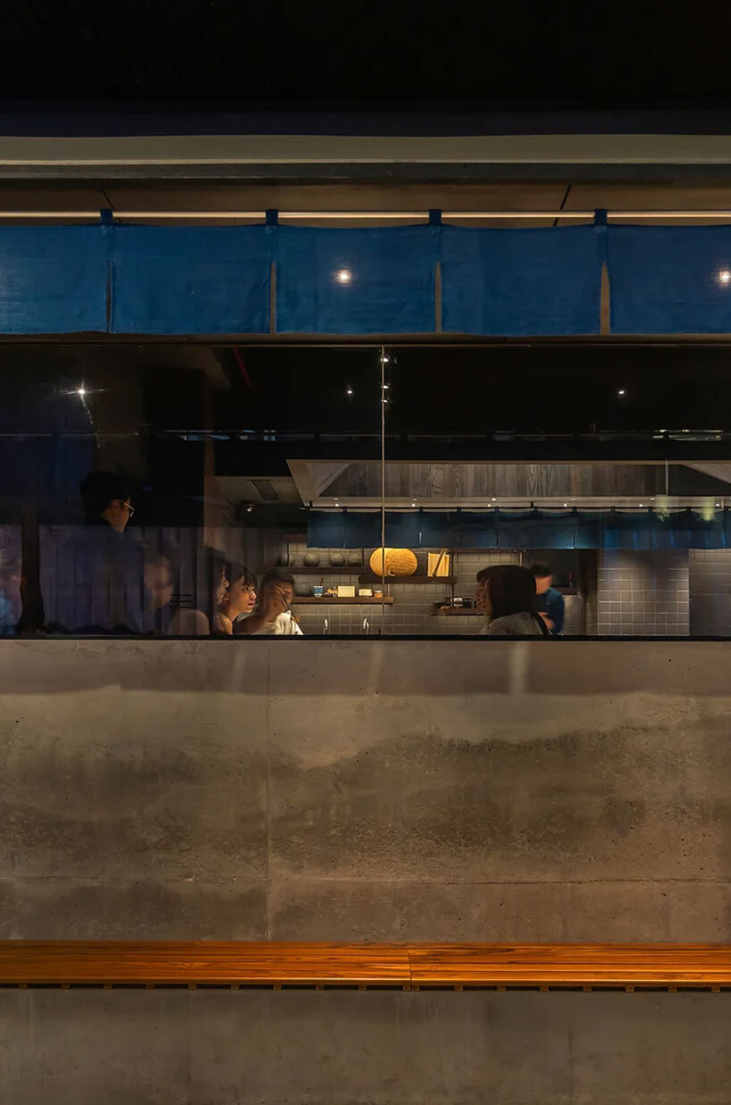 indigo fabric partitions float above sculpted concrete counters in rokusho bar by inrestudio