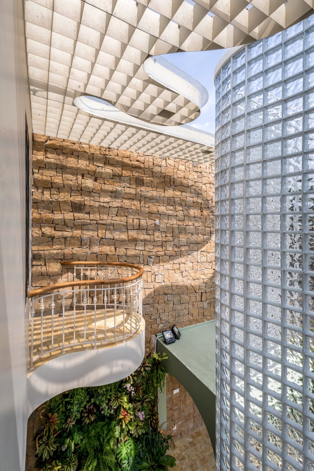 undulating facade of 3,000 glass bricks wraps DA VÀNG studio's crystal pavilion house in vietnam