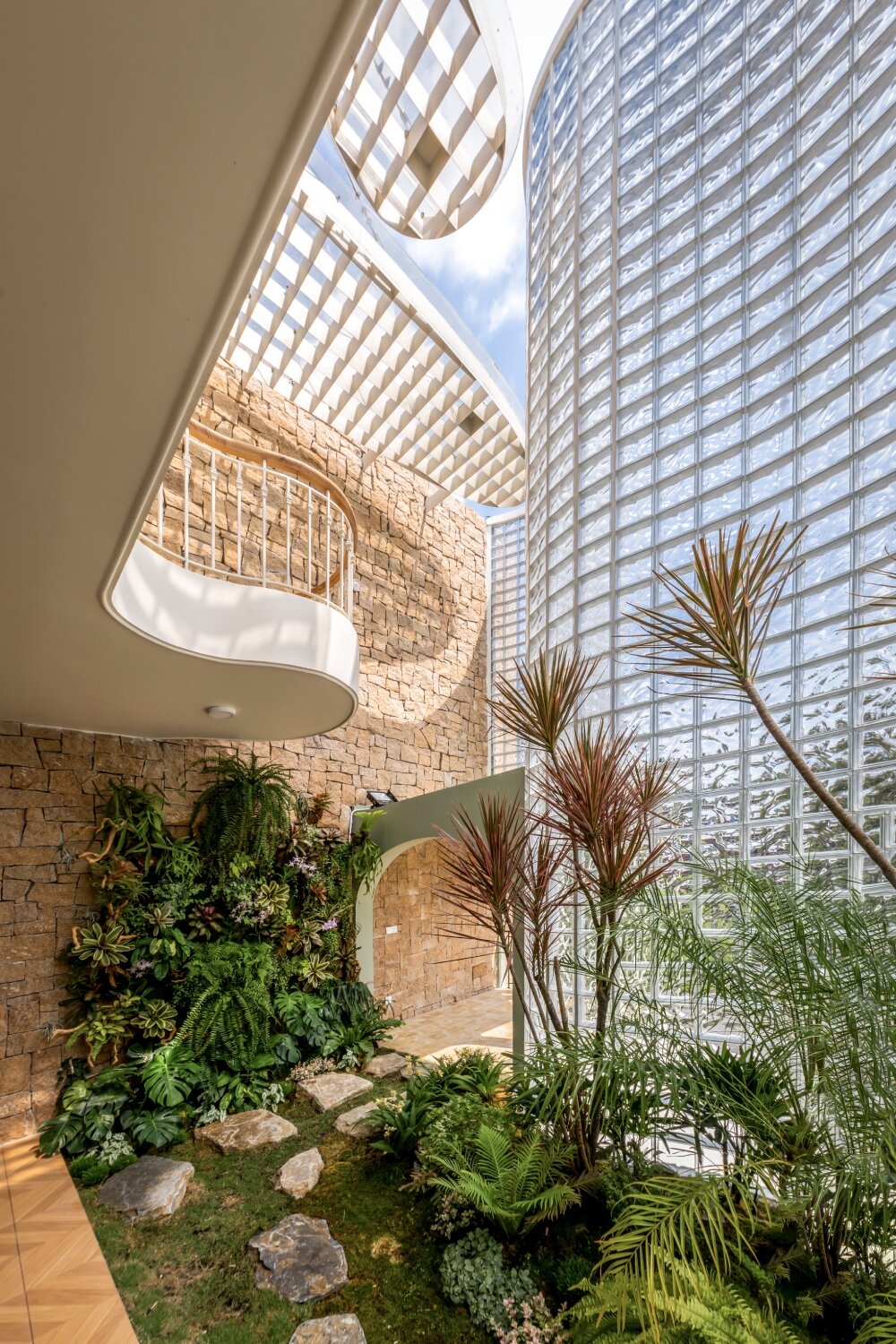 undulating facade of 3,000 glass bricks wraps DA VÀNG studio's crystal pavilion house in vietnam