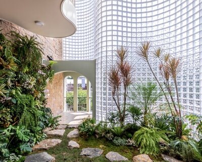 curved facade of 3,000 glass bricks wraps DA VÀNG studio's translucent house in vietnam
