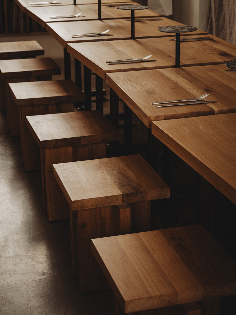 wiercinski-studio builds cozy 'amator' restaurant around modular oak table in copenhagen