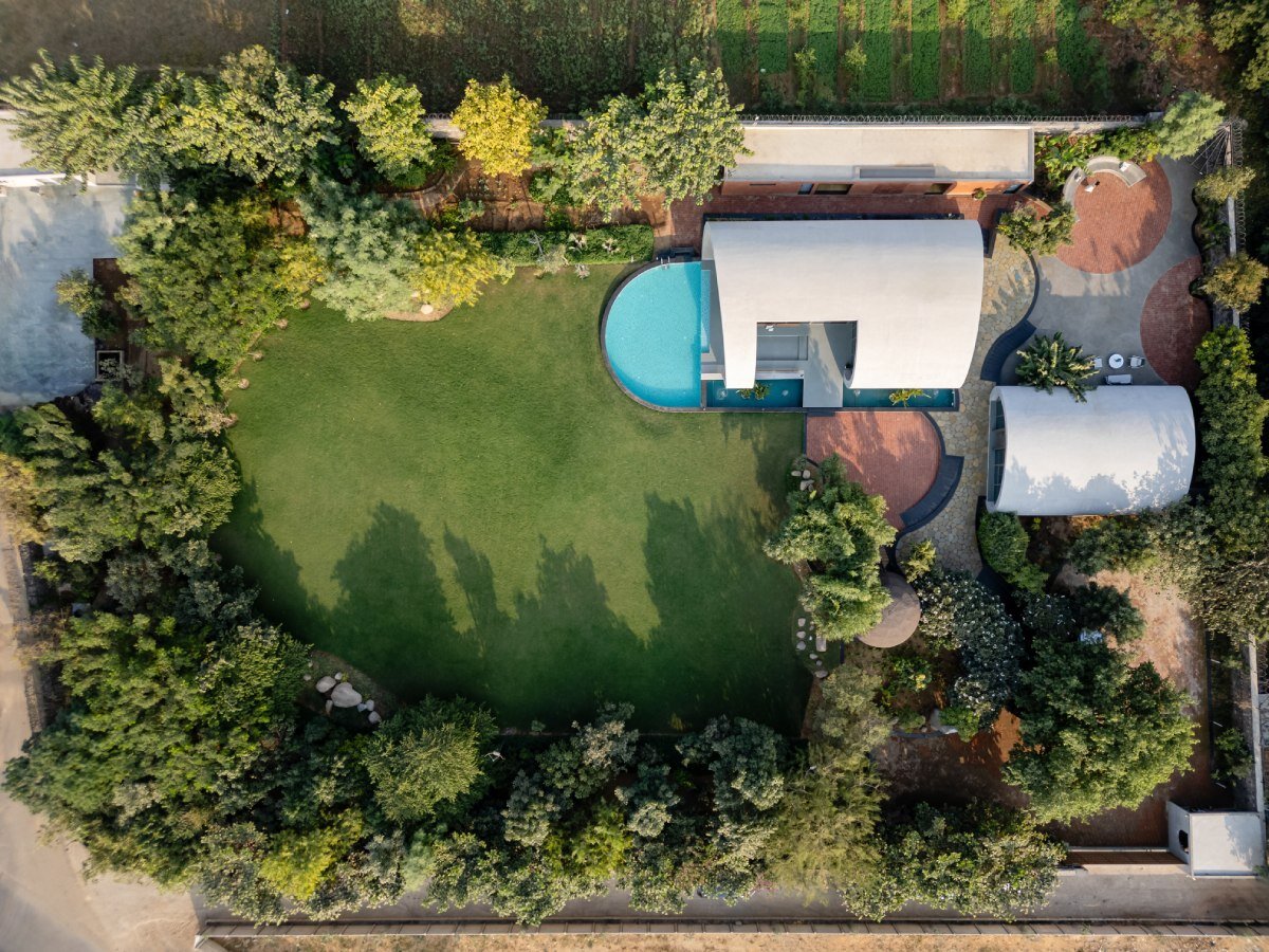 carapace house by achyutam designs carves into tubular concrete volumes in india