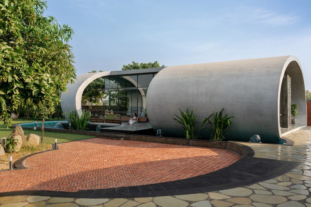 carapace house by achyutam designs carves into tubular concrete volumes in india