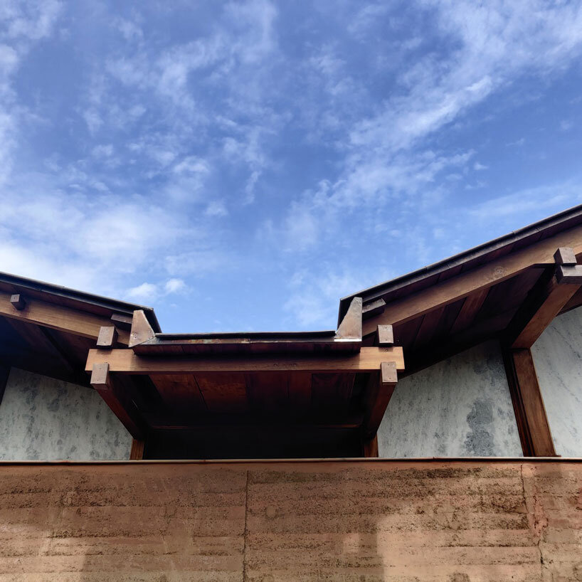 metis practice combines wooden shingles and copper for pali farmhouse's roofing in india