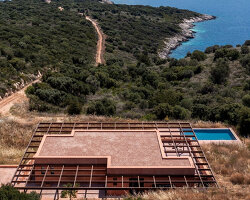 ateno's clay-coated house overlooks mountains and the sea on a greek island