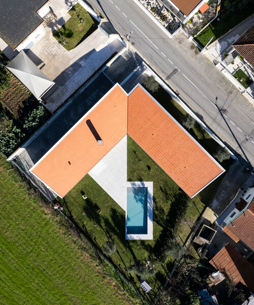 sculptural chimney pierces L-shaped house by martins architecture office in portugal