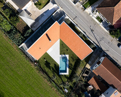 sculptural chimney pierces L-shaped house by martins architecture office in portugal