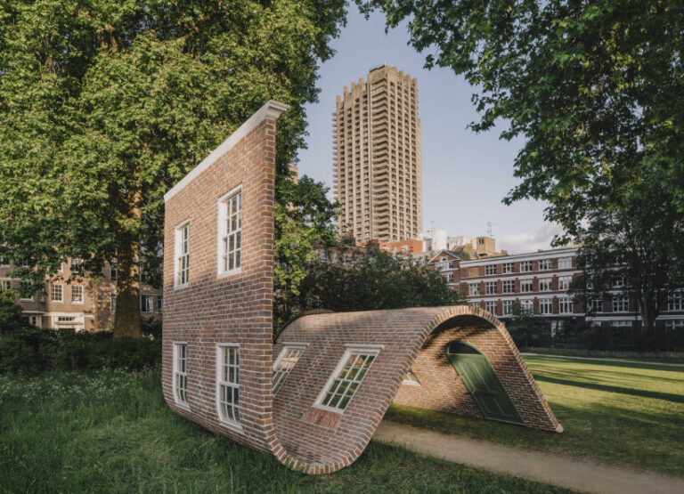 alex chinneck’s brick facade sculpture sits down in london