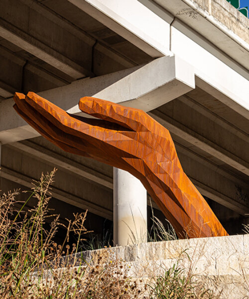 mark reigelman's oversized hand sculpture captures runoff water from overpass in texas