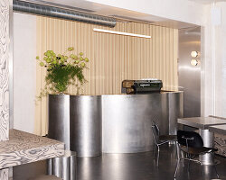 RDZ studio sculpts soft futurism into zurich café with floating cloud bar and tactile interiors