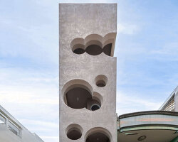 cloud-shaped openings pierce urban co-living unit's concrete facade in vietnam