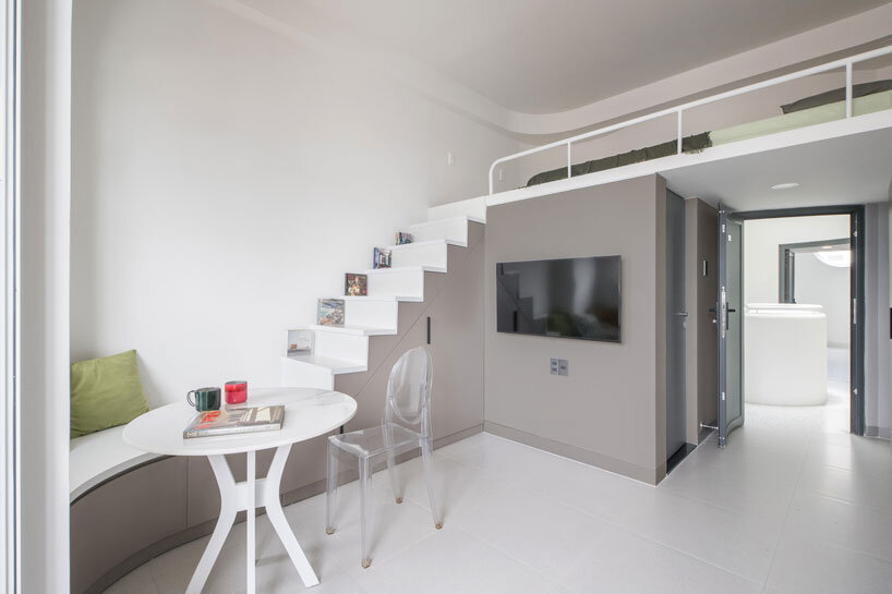 cloud-shaped openings pierce urban co-living unit's concrete facade in vietnam