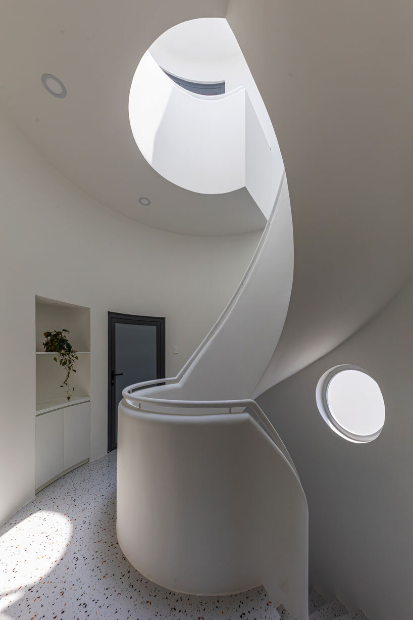 cloud-shaped openings pierce urban co-living unit's concrete facade in vietnam