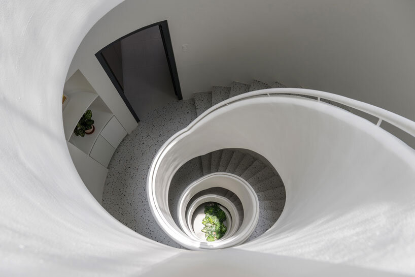 cloud-shaped openings pierce urban co-living unit's concrete facade in vietnam