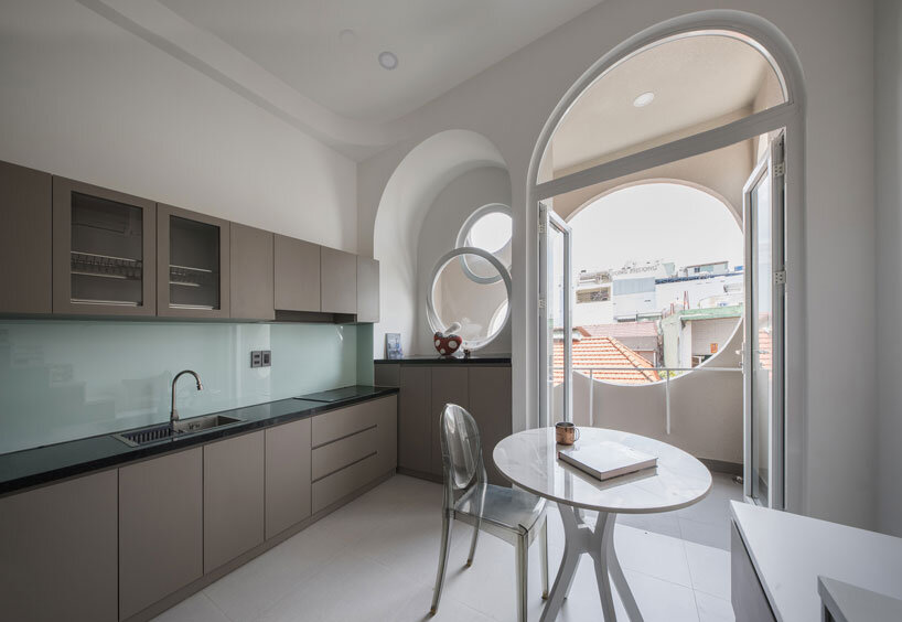 cloud-shaped openings pierce urban co-living unit's concrete facade in vietnam