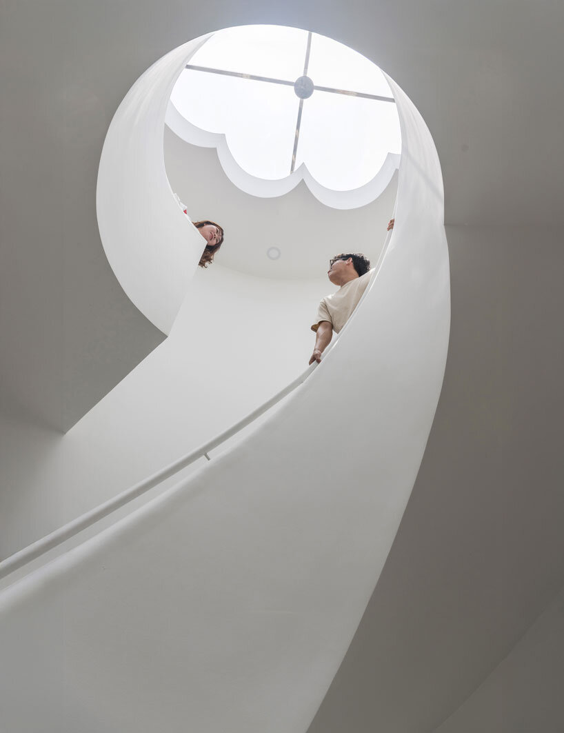 cloud-shaped openings pierce urban co-living unit's concrete facade in vietnam