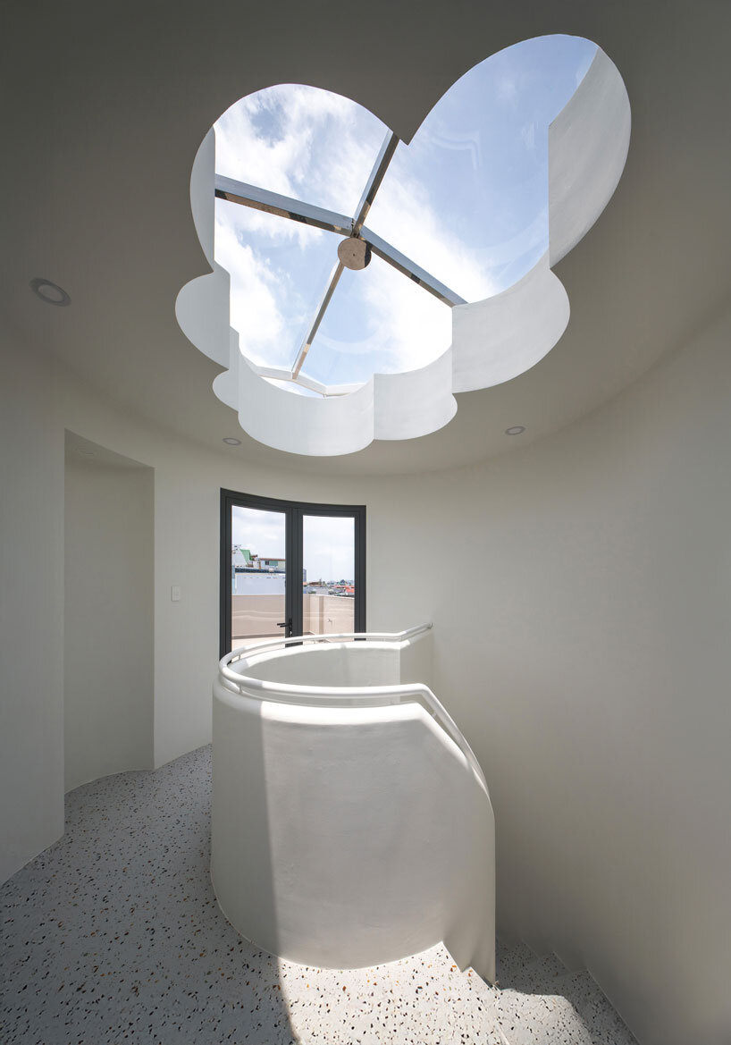 cloud-shaped openings pierce urban co-living unit's concrete facade in vietnam