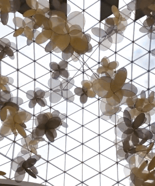 vincent leroy's kinetic installation of metallic mesh flowers floats above hainan island in china