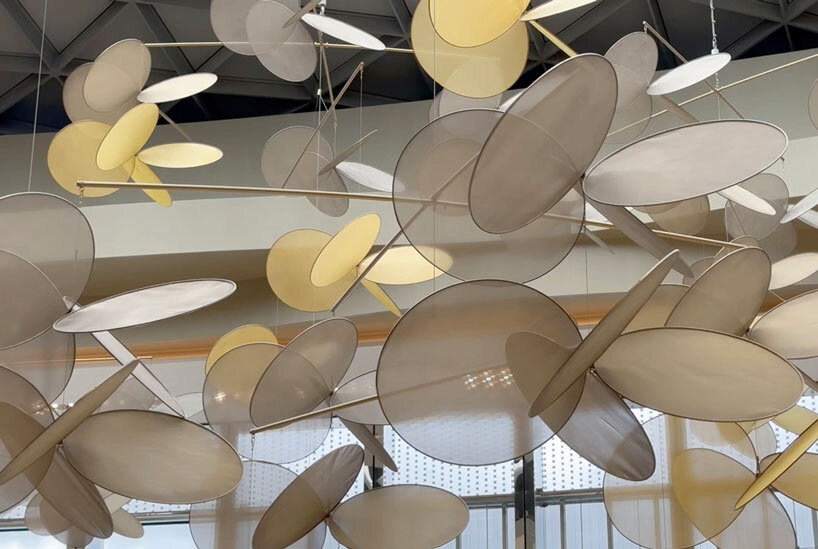 vincent leroy's kinetic installation of metallic mesh flowers floats above hainan island in china