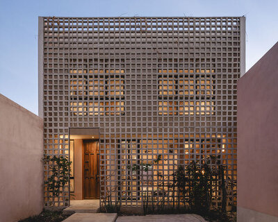 lattice skin encloses casa xcumpich's red volumes by taller mexicano de arquitectura