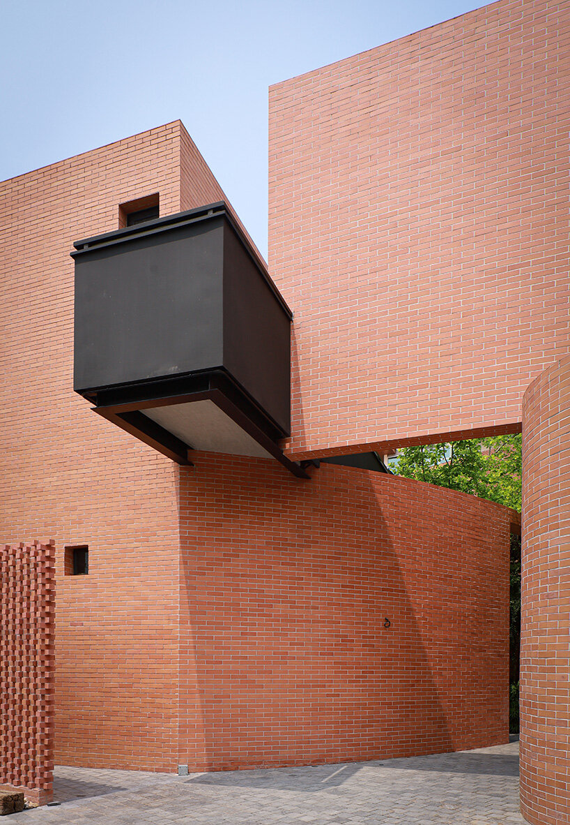 curved brick wall envelops volume matrix studio's multi-functional art space in bangkok