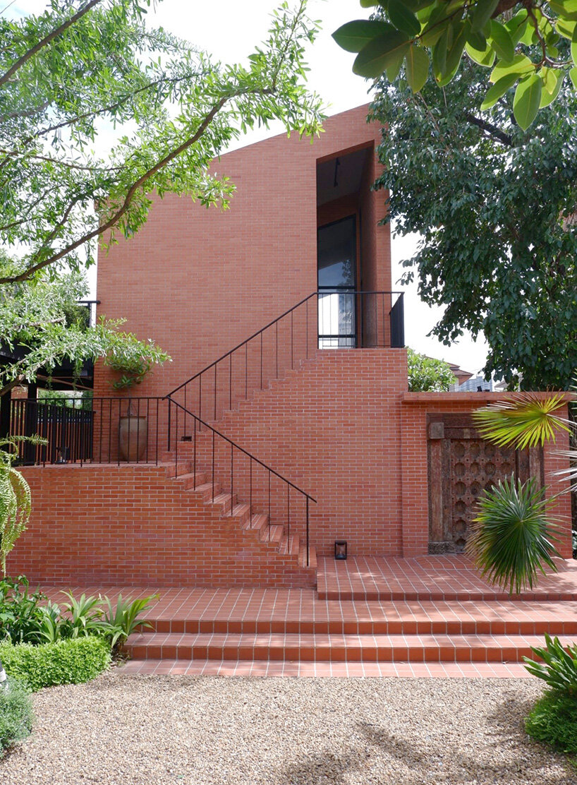 curved brick wall envelops volume matrix studio's multi-functional art space in bangkok