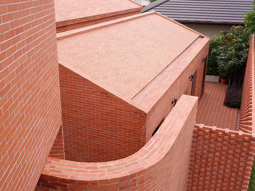 curved brick wall envelops volume matrix studio's multi-functional art space in bangkok