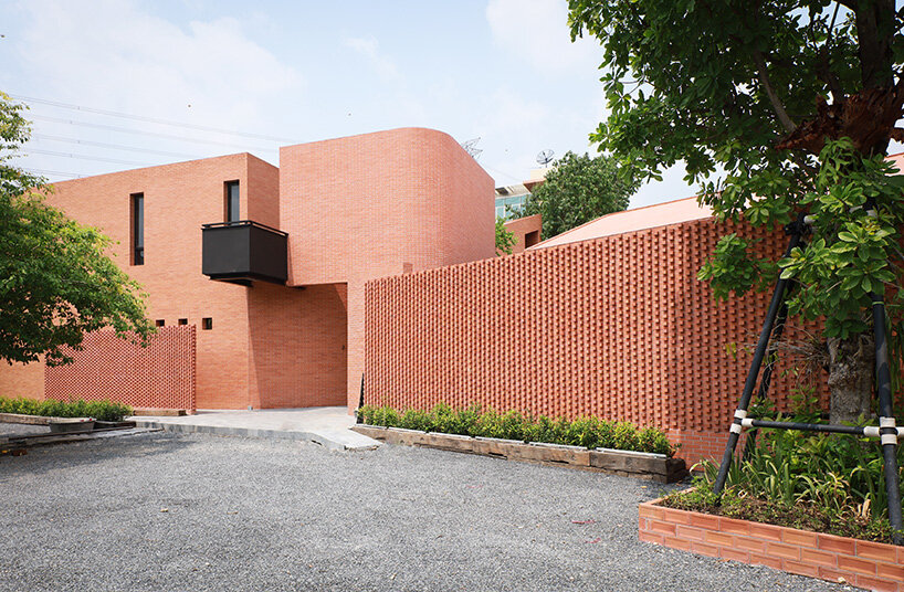curved brick wall envelops volume matrix studio's multi-functional art space in bangkok