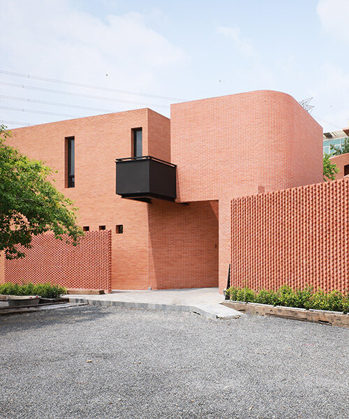 curved brick wall envelops volume matrix studio's multi-functional art space in bangkok