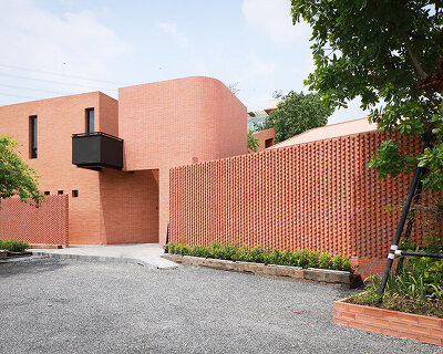 curved brick wall envelops volume matrix studio's multi-functional art space in bangkok