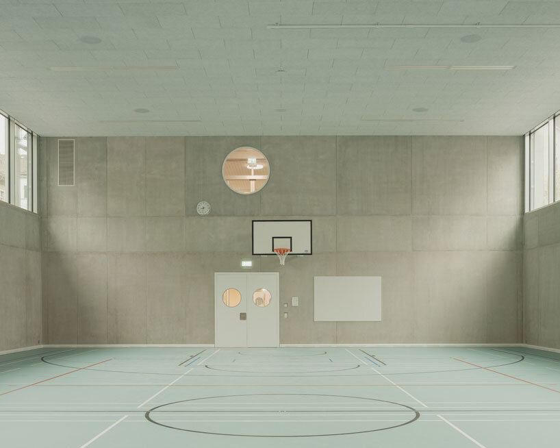 elevated concrete truss frame forms vocational school for construction trades in zurich