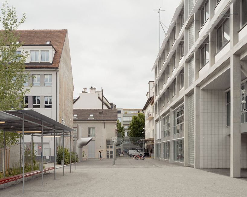 elevated concrete truss frame forms vocational school for construction trades in zurich