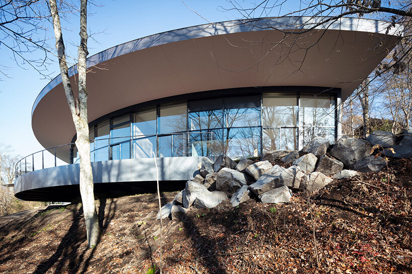 kamiya architects' residence–hotel hybrid traces sweeping arc through the japanese forest