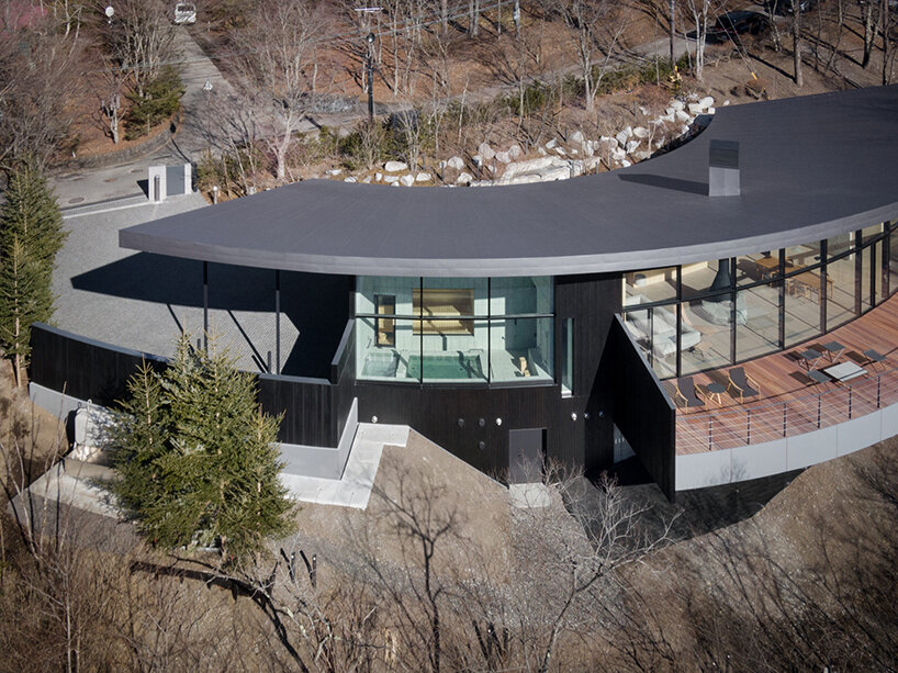 kamiya architects' residence–hotel hybrid traces sweeping arc through the japanese forest